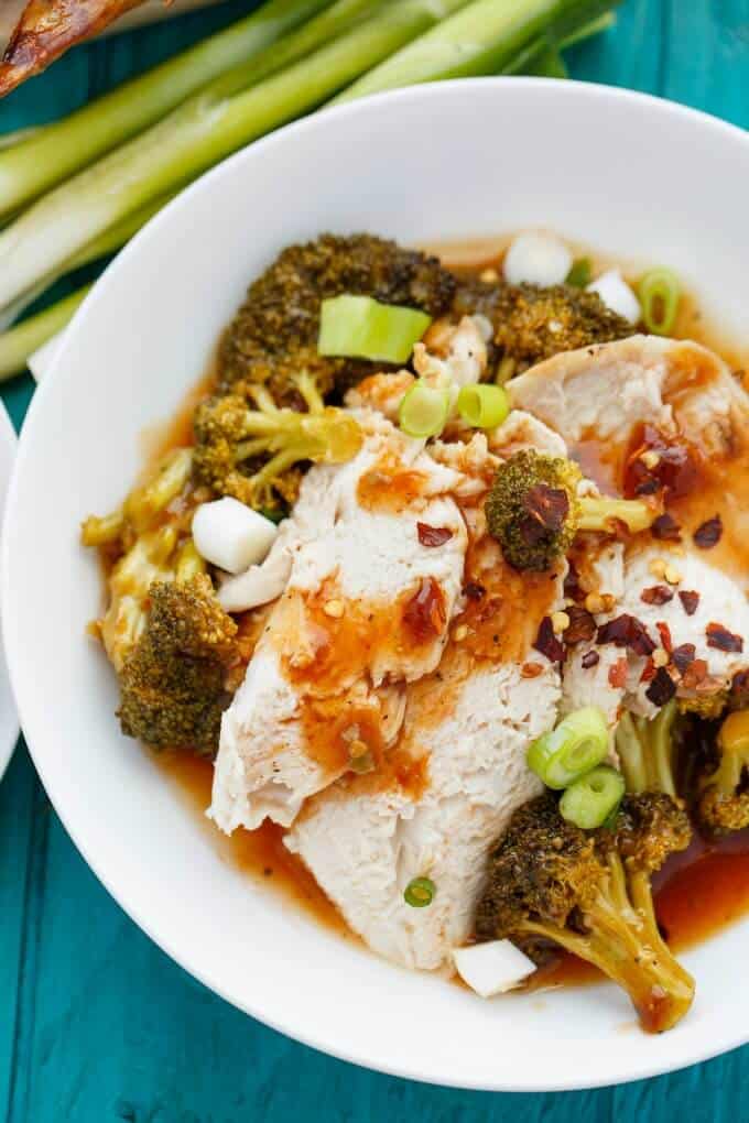 General Tso's Whole Chicken in the Slow Cooker on white plate with vegetable on plate and on blue table