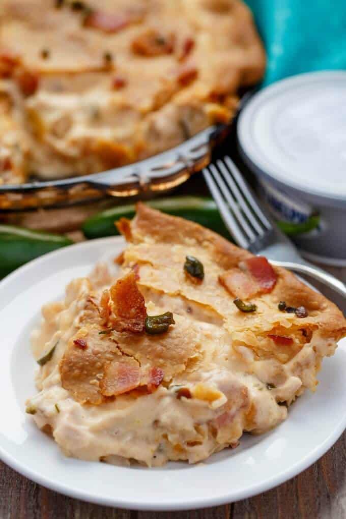Jalapeno Popper Chicken Pot Pie with Bacon on white plate and glass tray with fork and plastic container