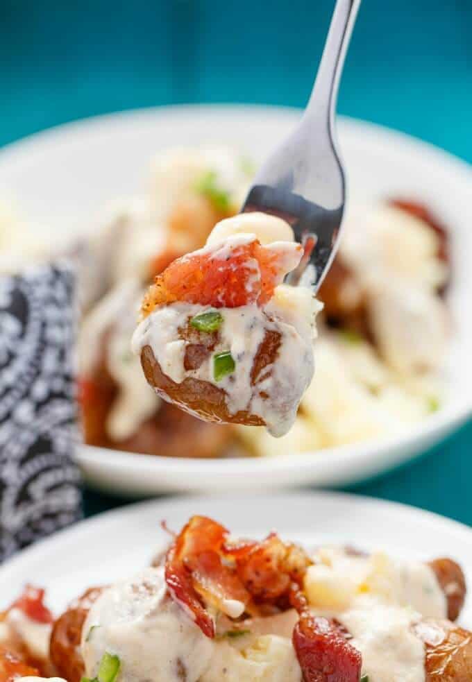 Jalapeno Popper Potato Poutine picked by fork over plate with same dish