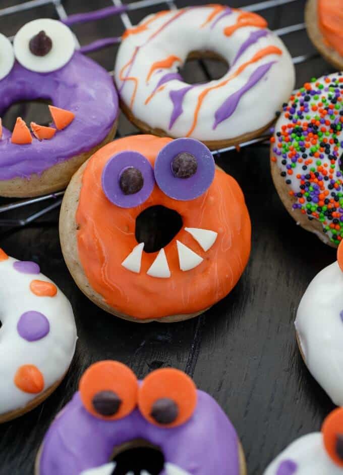Halloween Monster Doughnuts on black table and baking grid