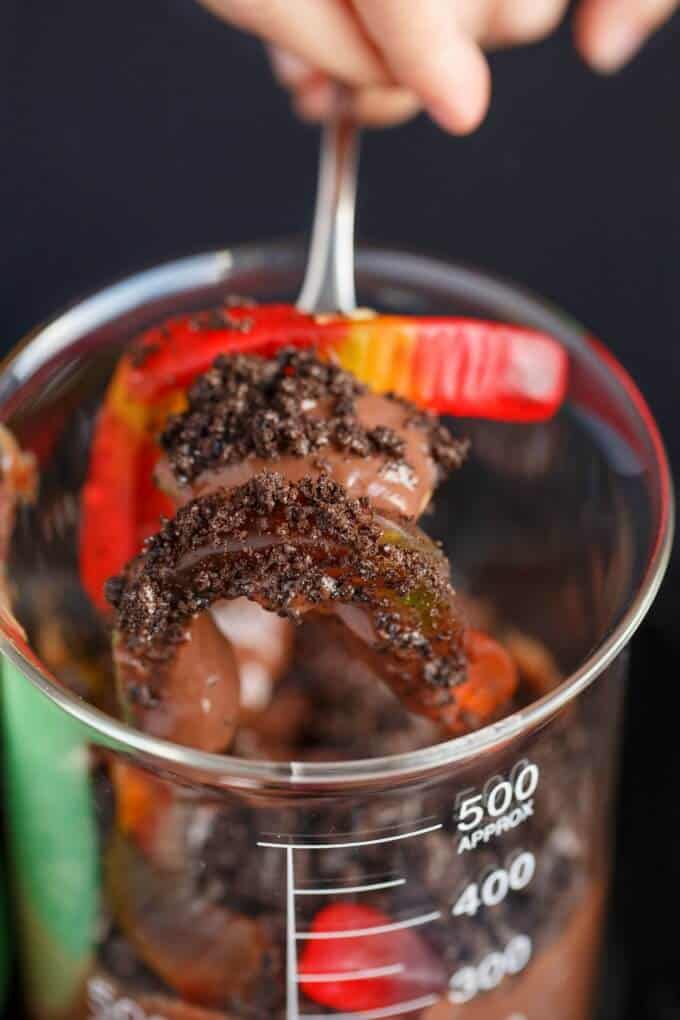 Homemade Worms and Dirt Dessert in glass jar picked on fork
