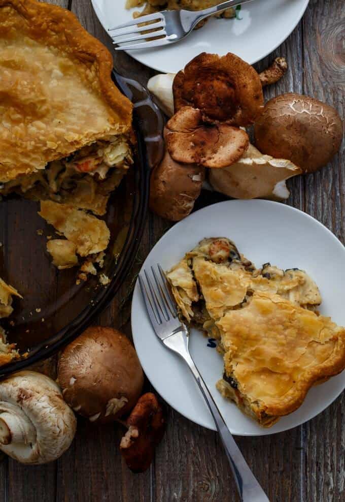 Roasted Mushroom Pot Pie on white plates with fork and on glass tray.. Mushroom on brown table