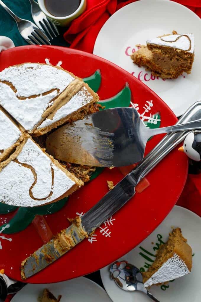 Gingerbread Cheesecake on chritmas themed tray with knife and spatula being served on plates 