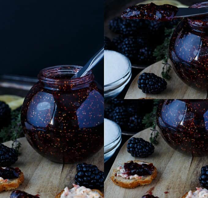 Blackberry fig jam in glass jar on wooden pad with blackberries and snacks