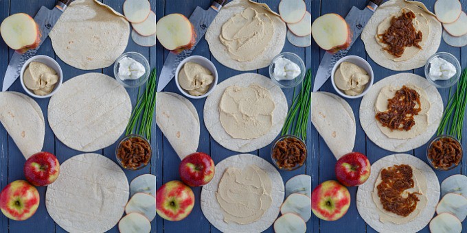 Caramelized Onion Apple Wraps with Hummus on blue table with herbs and apples