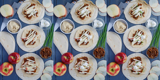 Caramelized Onion Apple Wraps with Hummus on blue table with apples and herbs