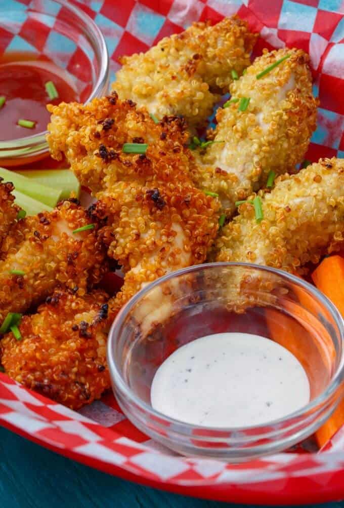 Quinoa-Crusted Chicken Nuggets with vegetable and dips on paper sheet