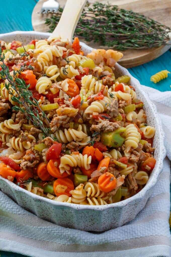 Loaded Vegetable Pasta  in Casserole with wooden spatula and herbs