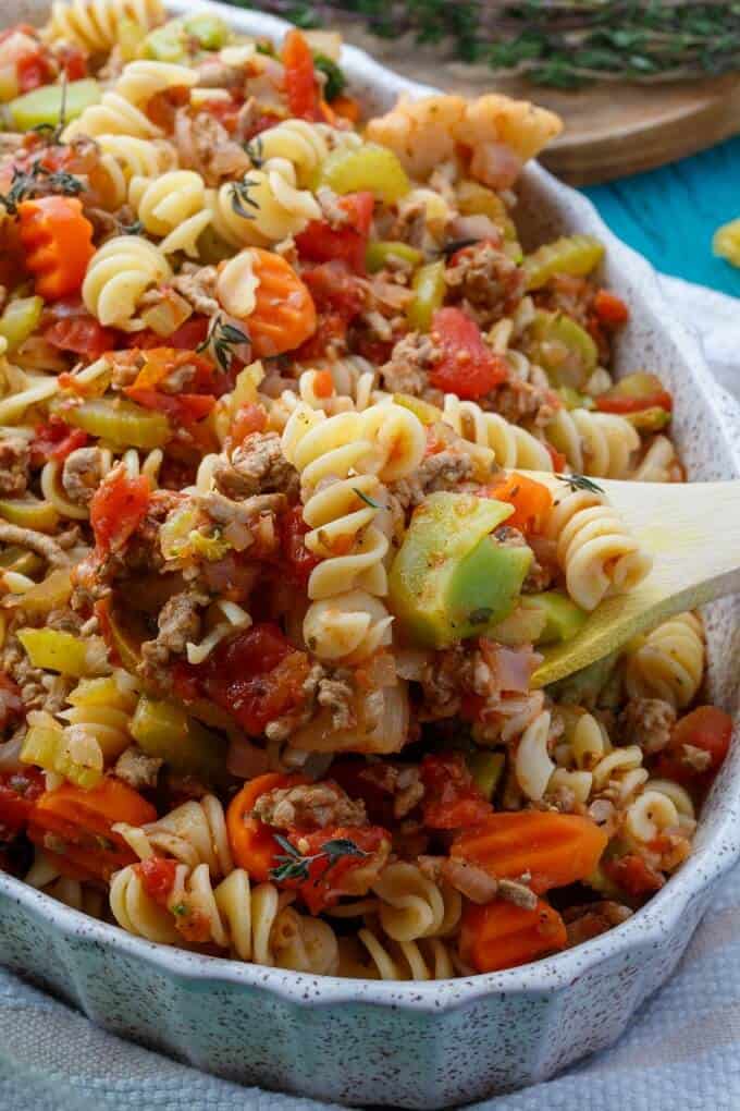 Loaded Vegetable Pasta in casserole with wooden spatula