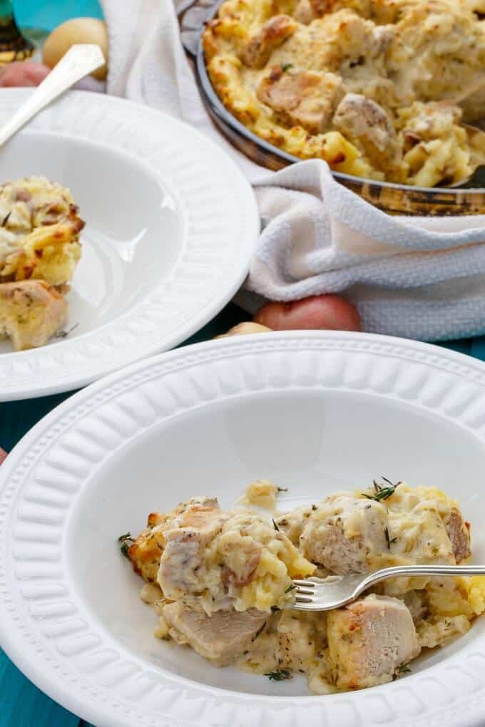 Mashed Potato Chicken Pie on white plates with forks, rest of dish in casserole in the background