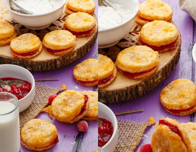 Cheesy Leftover Cranberry Sauce Cookies on wooden pad on purple table with glass of milk, cranberry sauce in bowl and bowl flour