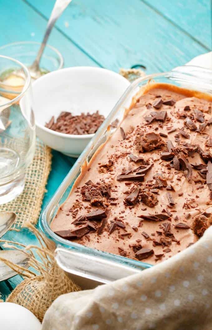 Dark Chocolate Blue Cheese Ice Cream with Honey on glass container on blue table with bowls of ingredients