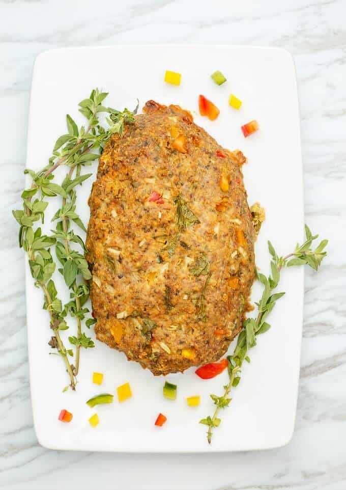 Slow Cooker Turkey Meatloaf on white tray with vegetables and herbs (Veggie Loaded!)