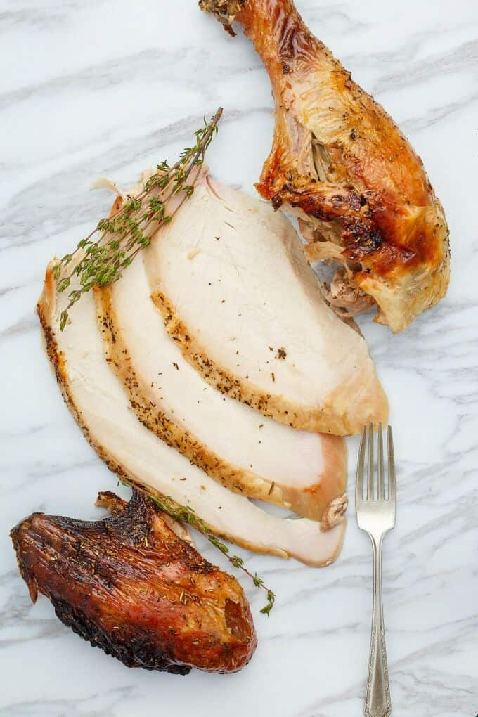Grilled Herbes de Provence Turkey  on white gray table with herbs and fork
