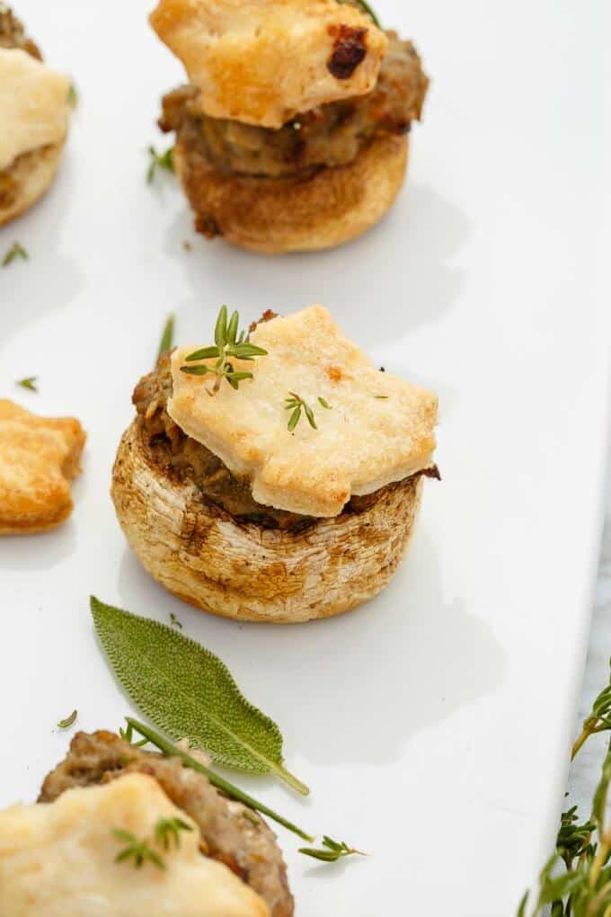 Tourtiere Stuffed Mushrooms on white tray with herbs (Meat Pie Mushrooms)