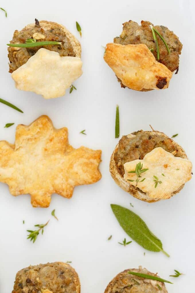 Tourtiere Stuffed Mushrooms on white tray with herbs (Meat Pie Mushrooms)