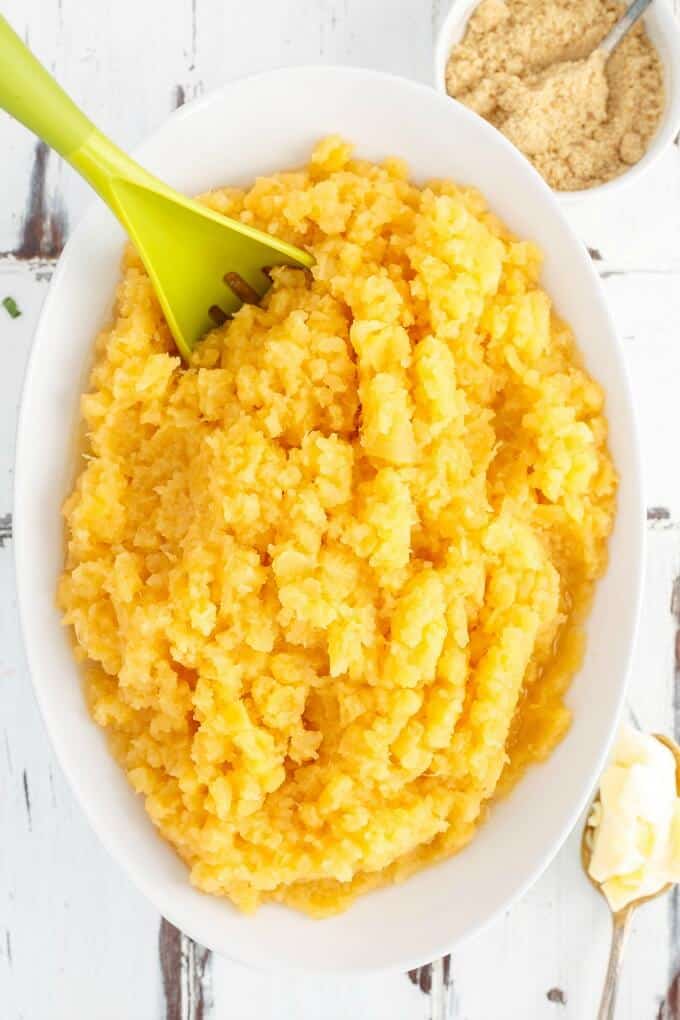 Mashed Rutabaga in green bowl with green spatula