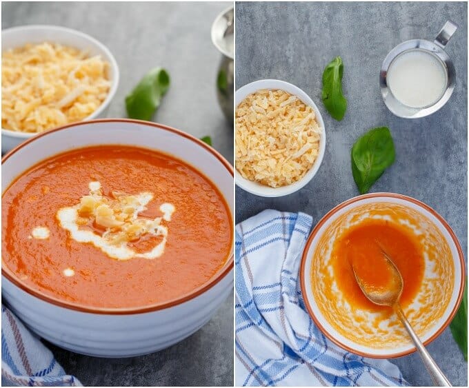 Roasted Red Pepper Soup with Gouda in white orange bowl with bowl of  gouda and herbs. Soup in bowl being mixed by spoon next to herbs, cloth wipe, bowl of gouda and jar of milk