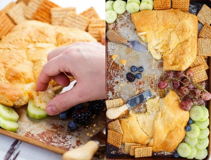 Canadian Cheese Stuffed Crescent Rolls on wooden pad held by hand with cucumber, blackberries and blueberries, crackers. Cheese stuffed rolls on tray with crackers, blackberries, blueberries, grapes, cucumber and knifes