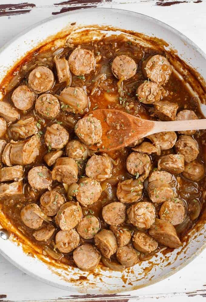 Beer Gravy Sausage Dinner in pot with wooden spatula