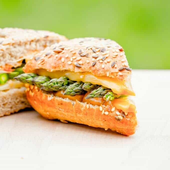 Grilled cheese and asparagus sandwich on white plate
