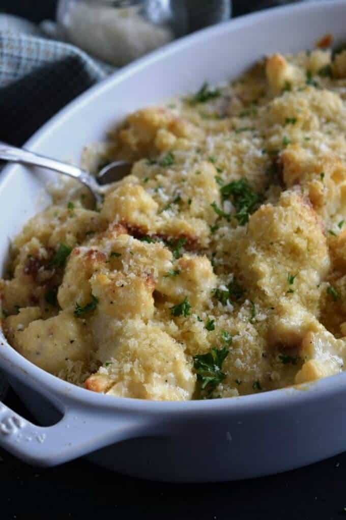 Oven roasted cauliflower and cheddar gratin in bowl with spoon