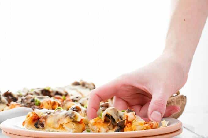 Vegetarian Mushroom Pizza Bread  on white plate held by hand 