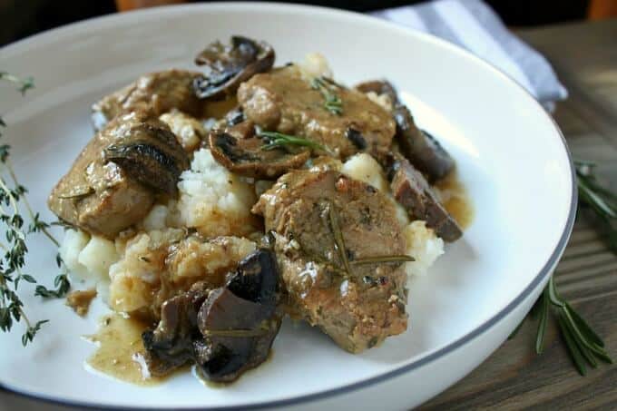 Instant pot pork medallions with herbs and mushrooms on white plate