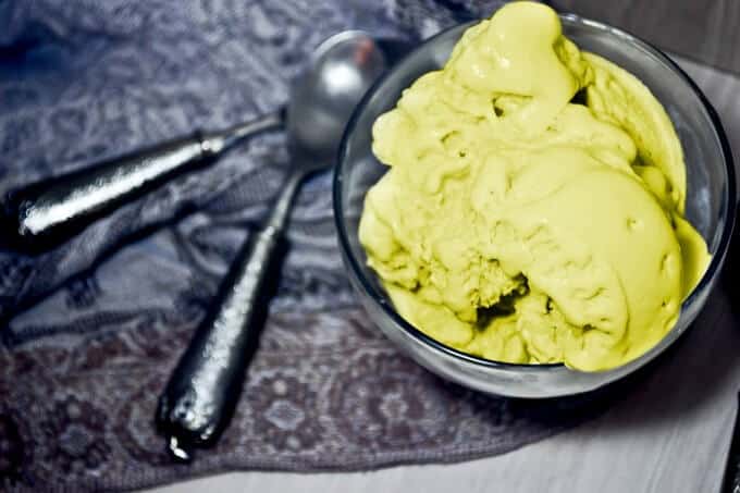 Matcha ice cream in glass bowl , spoons and cloth table on white table