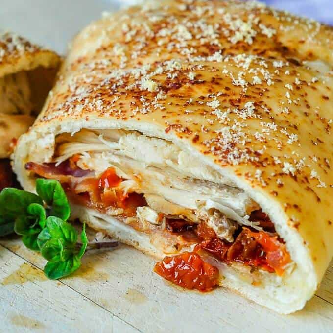 Turkey club stromboli with herb on wooden table