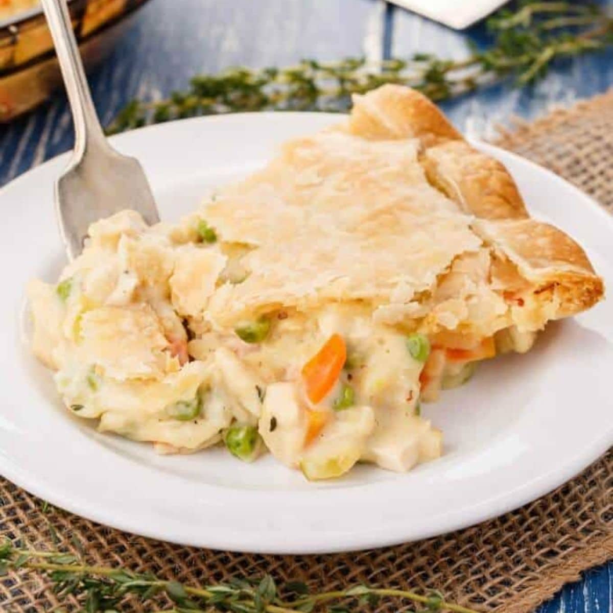 Homemade turkey pot pie in white plate with fork