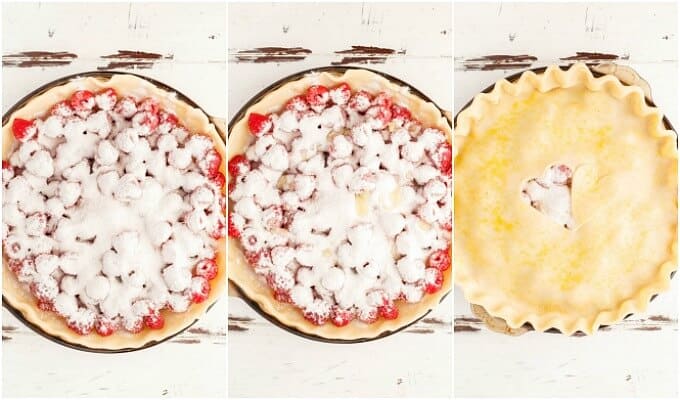 Homemade Raspberry Pie dough in baking pot with raspberries with sugar and dough with cutted heart on the top on white brown table