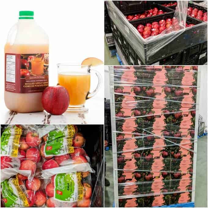 Apple juice in container and glass cup with red apple on white table. Apples in black boxes. Apples in plastic packages. Stack of apple packages on palet