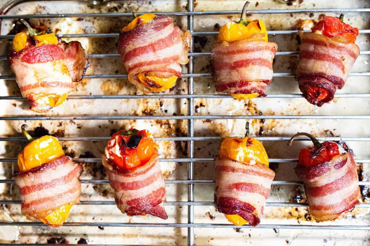 Mouth-watering Bacon-wrapped Stuffed Pepper Poppers on a resting grid.