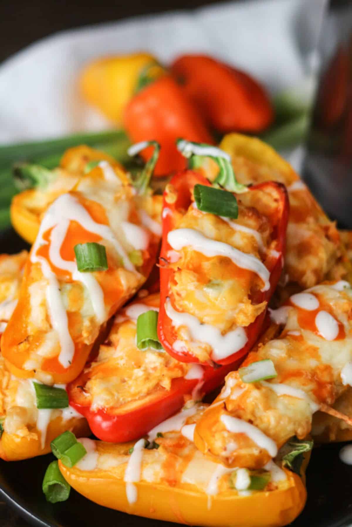 Scrumptious Buffalo Chicken Stuffed Mini Peppers on a black plate.