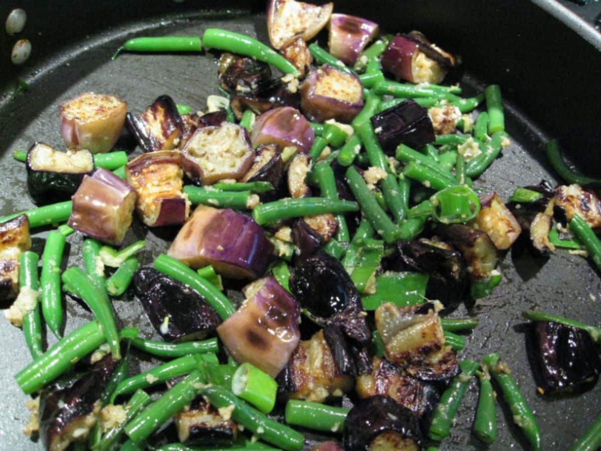 Delicious Eggplant Stir-Fry With Green Beans and Cashews in a skillet.