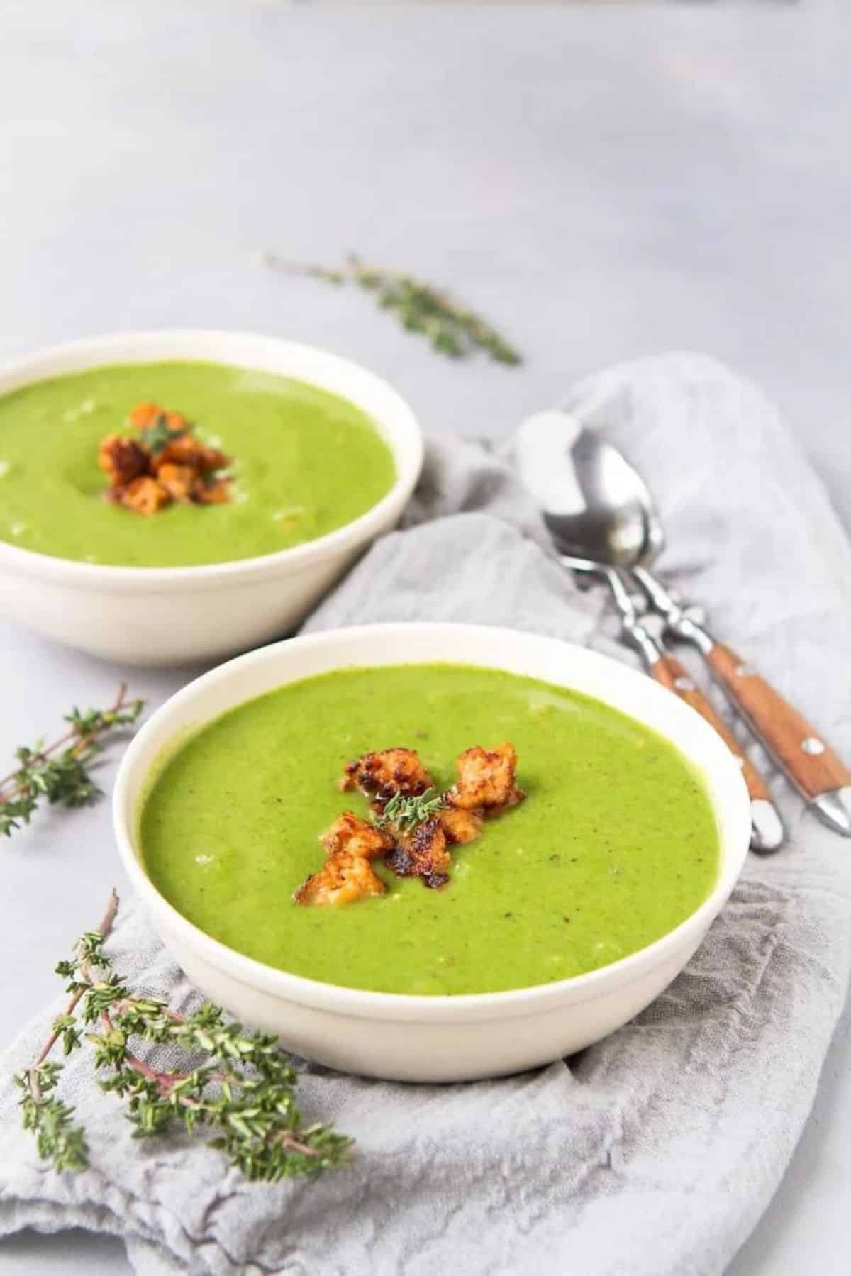 Creamy Cauliflower Spinach Soup in two white bowls.