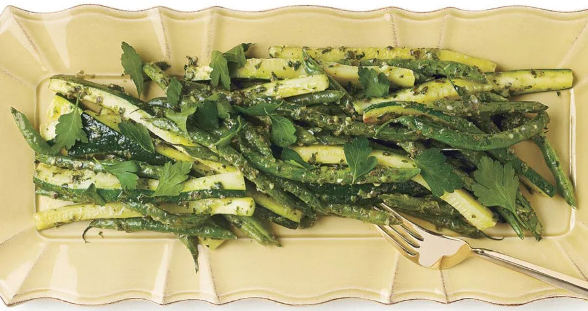 Healthy Green Beans and Zucchini With Sauce Verte on a yellow tray.