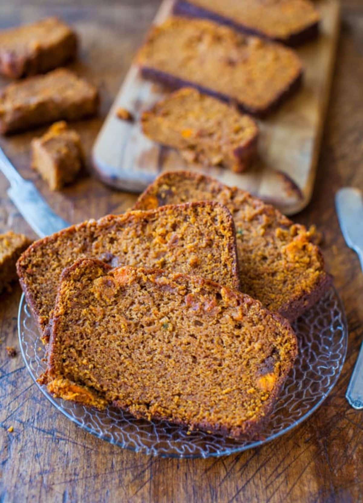 Three slices of Cinnamon and Spice Sweet Potato Bread on a glass plate.