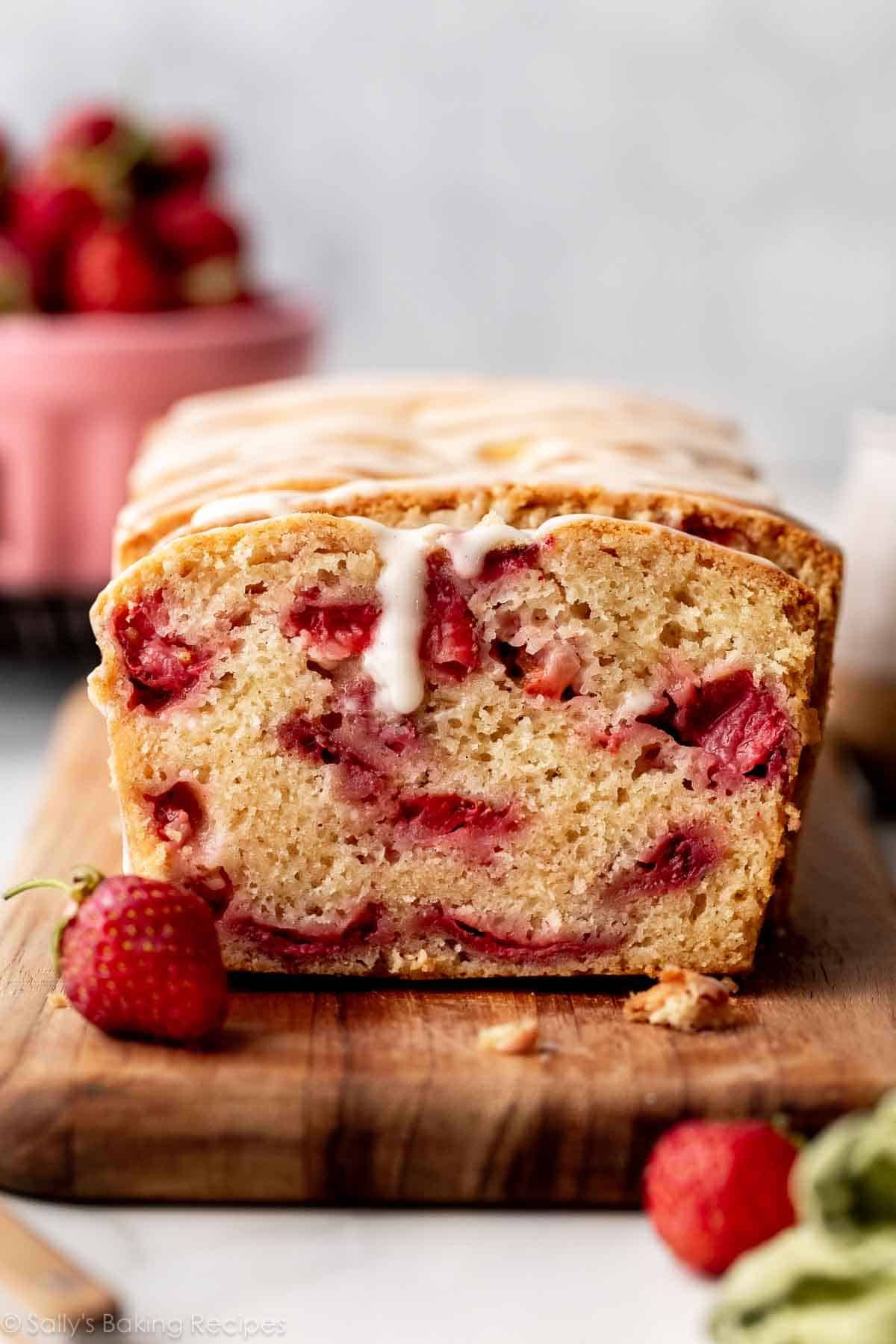 Delicious Glazed Strawberry Bread on a wooden cutting board.