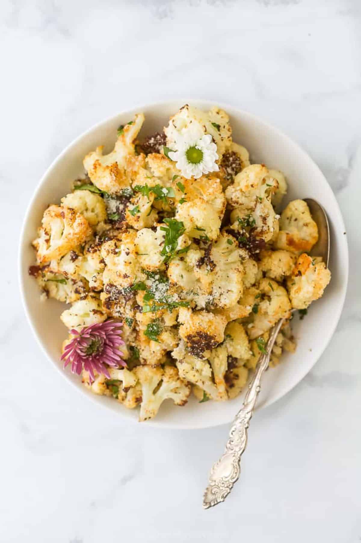 Delicious Parmesan Roasted Cauliflower in a bowl with a spoon.