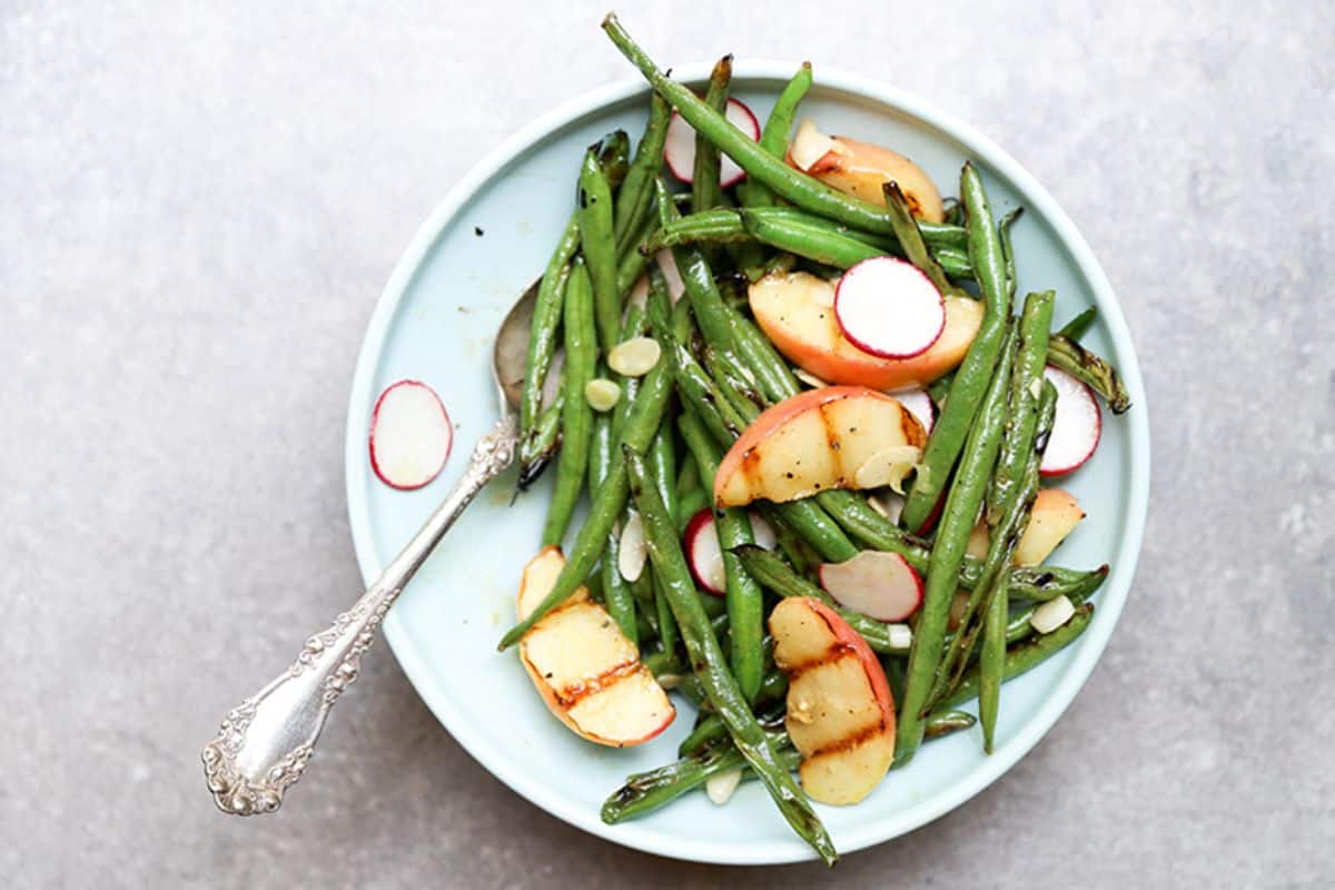 Fresh Grilled Green Bean and Apple Salad on a blue plate with a fork.