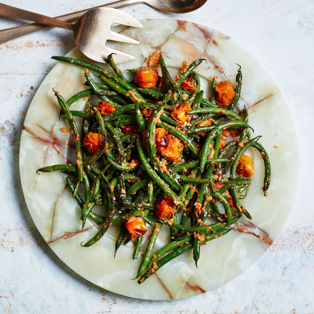 Mouth-watering Blistered Green Beans With Tomato-Almond Pesto on a plate.