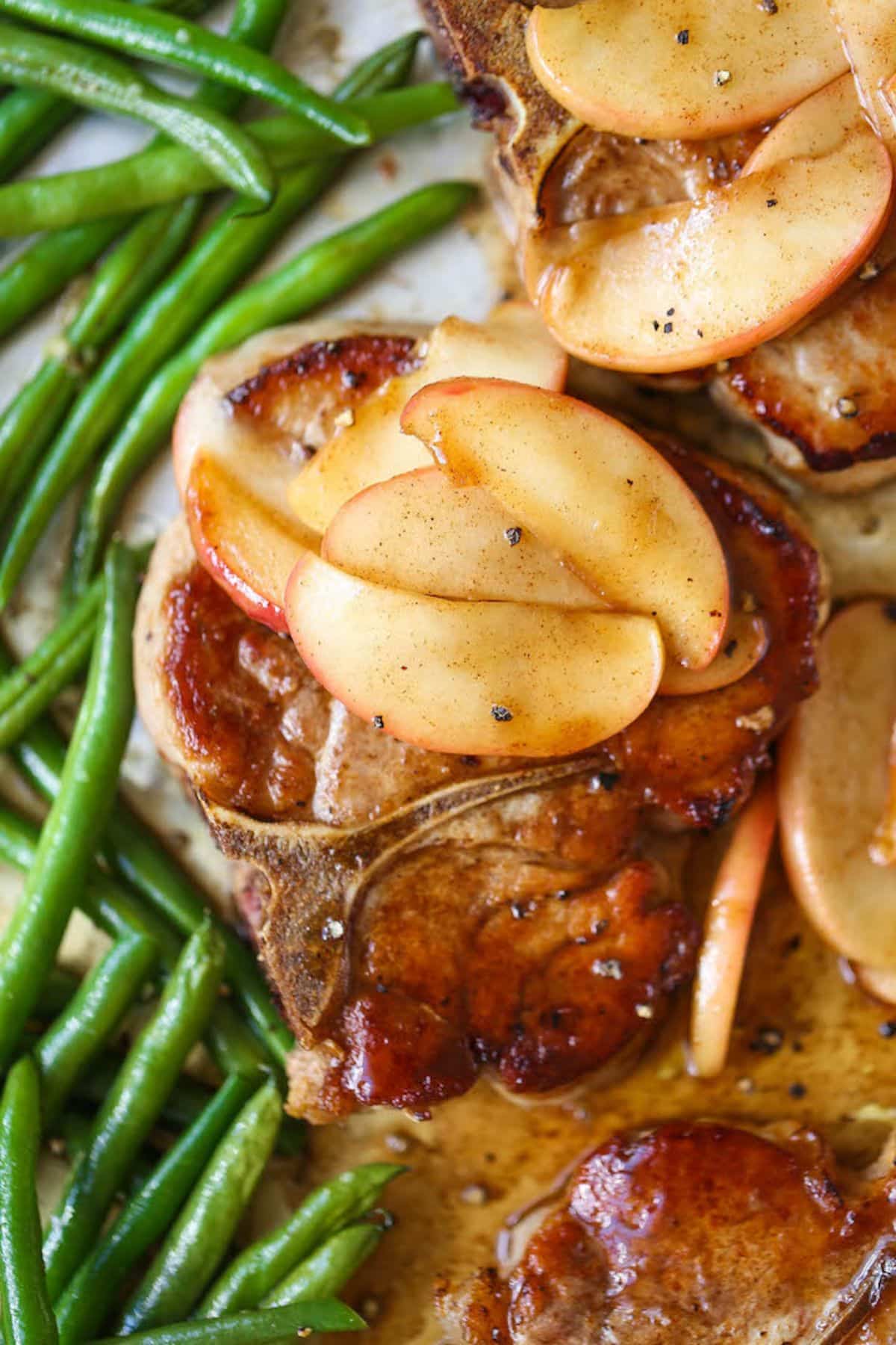 Juicy Baked Apple Pork Chops and Green Beans on a plate.
