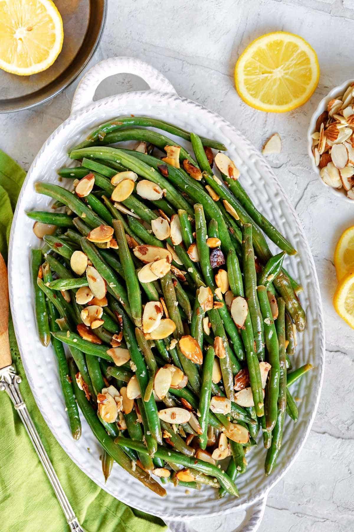 Flavorful Green Beans With Almondine on a white tray.