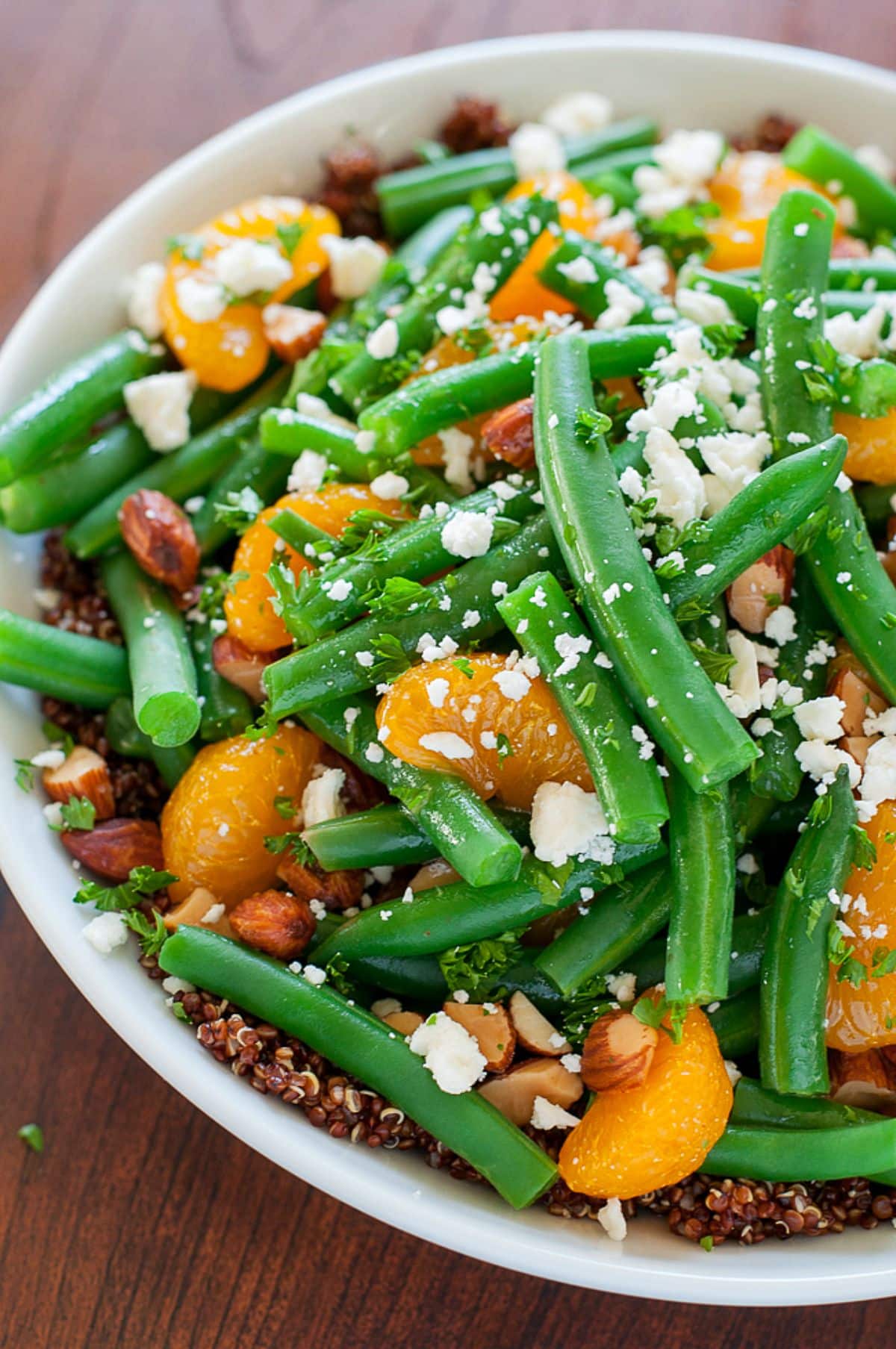 Healthy Green Bean Quinoa Salad With Maple Citrus Dressing in a white bowl.