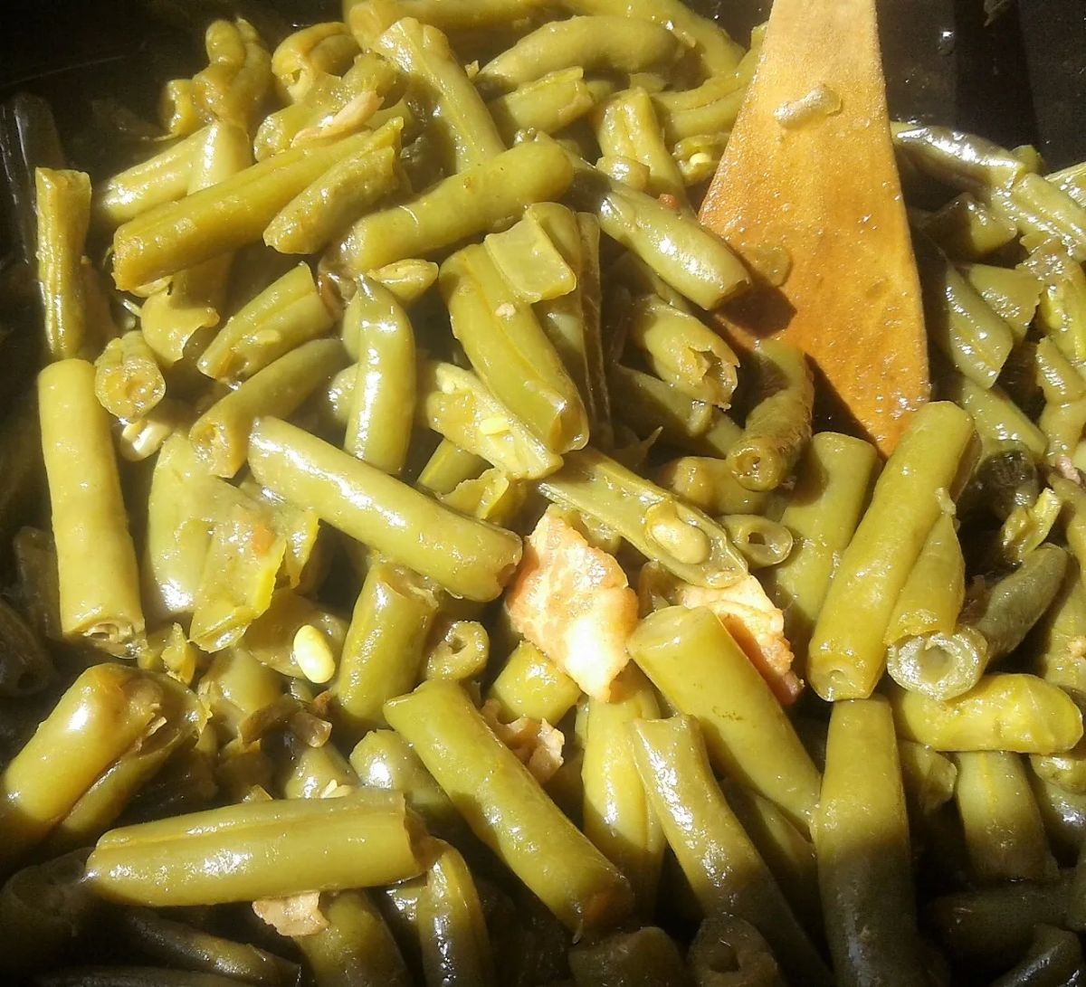 Healthy Crockpot Mississippi Green Beans with a wooden spoon.