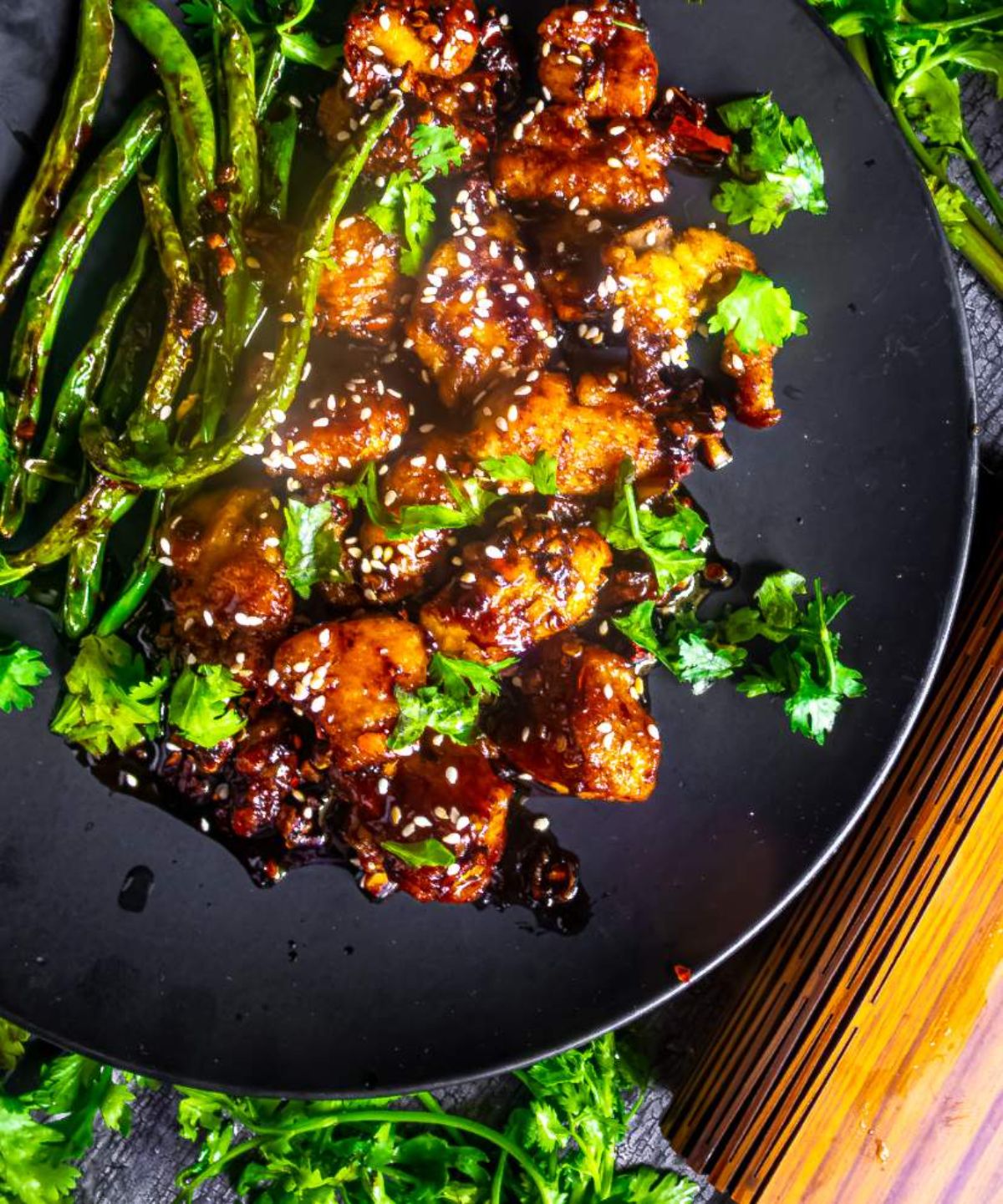 Delicious Asian-Style Chicken and Green Beans on a black plate.