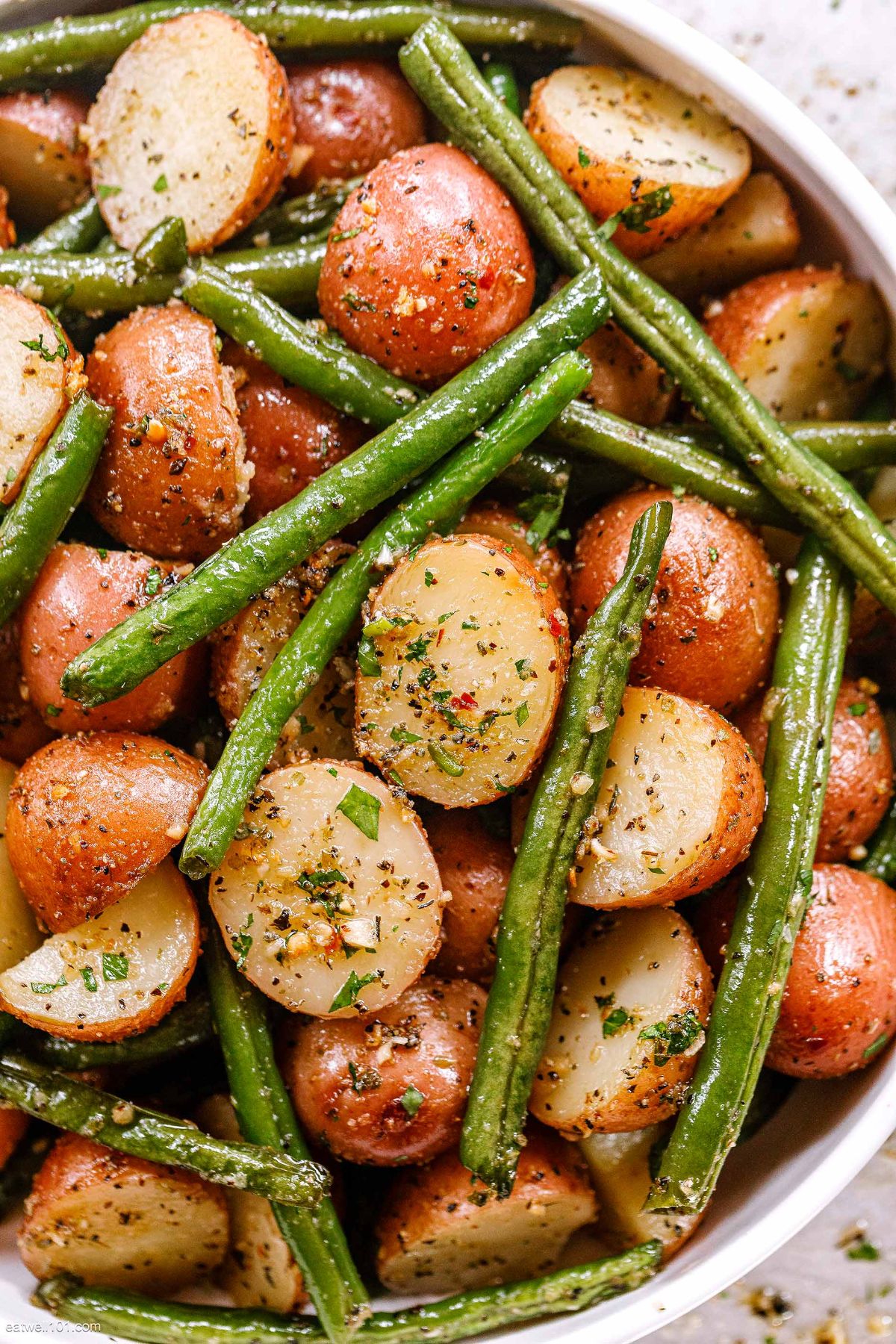 Mouth-watering Roasted Garlic Potatoes and Green Beans in a white bowl.