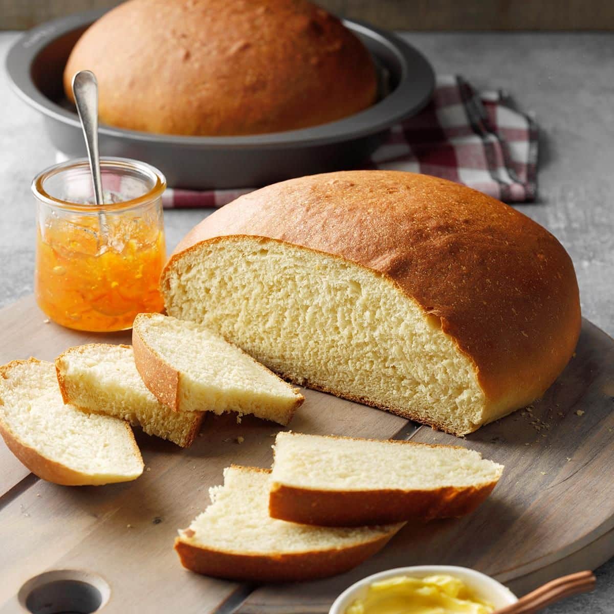 Partially sliced Hawaiian Sweet Bread on a wooden cutting board.